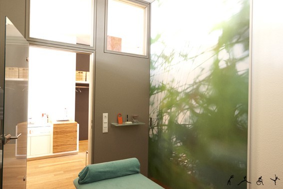 Moderner Behandlungsraum für Physiotherapie mit Naturmotiv und entspannter Atmosphäre.